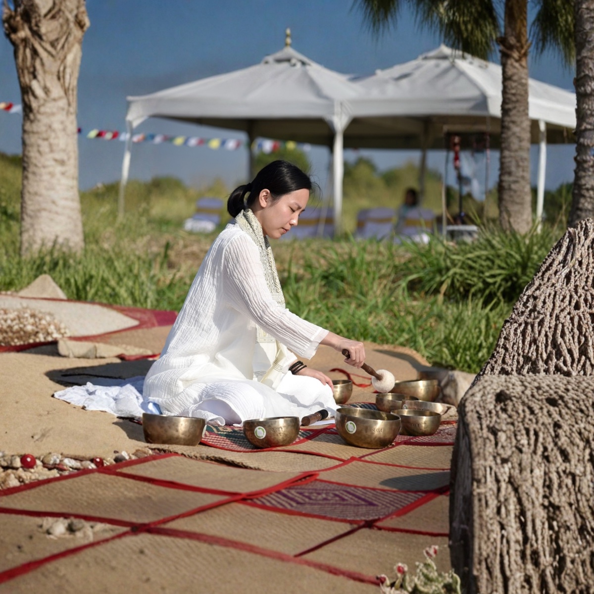 Mandy Mak playing singing bowls outdoors